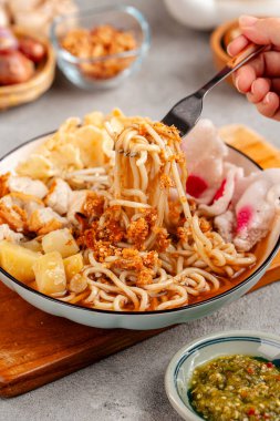 Emie, mie rebus haşlanmış yumurta ve patates, kurutulmuş karides, kızarmış soğan ve soğan yaprağından yapılan erişte çorbası..