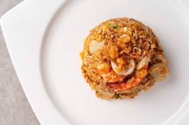 Asya usulü kızarmış pirinç (Endonezya usulü: nasi goreng) kalamar, karides ve balık baso ile birlikte.