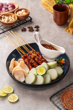 Sate Kacang ya da Chicken satay Endonezya 'nın geleneksel yemeği ızgara et ve pirinç keki ile şişlenmiş ve fıstık soslu.