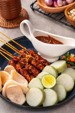 Sate Kacang ya da Chicken satay Endonezya 'nın geleneksel yemeği ızgara et ve pirinç keki ile şişlenmiş ve fıstık soslu.