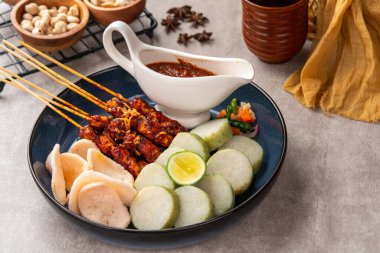 Sate Kacang ya da Chicken satay Endonezya 'nın geleneksel yemeği ızgara et ve pirinç keki ile şişlenmiş ve fıstık soslu.