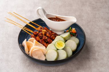 Sate Kacang ya da Chicken satay Endonezya 'nın geleneksel yemeği ızgara et ve pirinç keki ile şişlenmiş ve fıstık soslu.