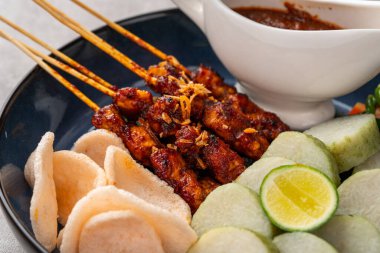 Sate Kacang ya da Chicken satay Endonezya 'nın geleneksel yemeği ızgara et ve pirinç keki ile şişlenmiş ve fıstık soslu.