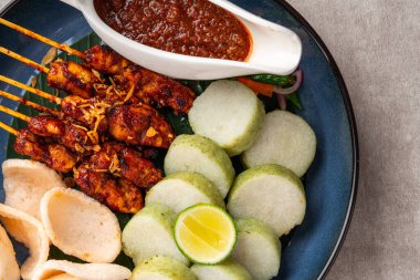 Sate Kacang ya da Chicken satay Endonezya 'nın geleneksel yemeği ızgara et ve pirinç keki ile şişlenmiş ve fıstık soslu.