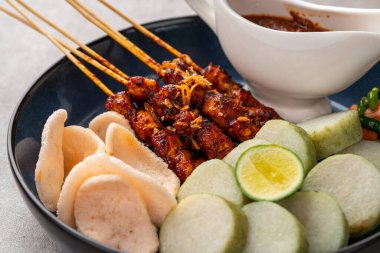 Sate Kacang ya da Chicken satay Endonezya 'nın geleneksel yemeği ızgara et ve pirinç keki ile şişlenmiş ve fıstık soslu.