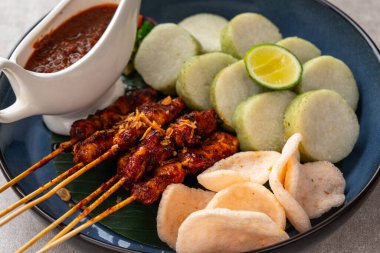 Sate Kacang ya da Chicken satay Endonezya 'nın geleneksel yemeği ızgara et ve pirinç keki ile şişlenmiş ve fıstık soslu.