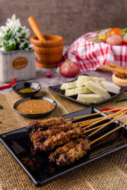 Pork Satay ya da Sate Babi. Pork Satay, fıstık sosu ve bir dilim lontong veya ketupat ile servis edilir.)