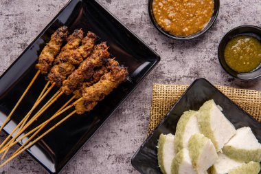 Pork Satay ya da Sate Babi. Pork Satay, fıstık sosu ve bir dilim lontong veya ketupat ile servis edilir.)