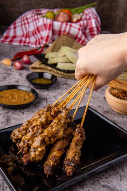 Pork Satay ya da Sate Babi. Pork Satay, fıstık sosu ve bir dilim lontong veya ketupat ile servis edilir.)