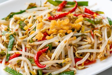 Tumis Tauge ikan asin ya da Salted Bean Sprout Endonezya 'nın geleneksel yemeklerinden biridir. Tabakta servis edilen tuzlu balıkla pişirilmiş sotelenmiş fasulye filizi ve izole edilmiş gri arka plan..