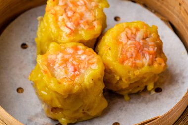 Bambu sepetinde çeşit çeşit Çin Dimsum 'u. Dimsum, Kanton halkının geleneksel olarak kahvaltı ve öğle yemeği için restoranlarda yediği küçük tabakların geniş bir yelpazesidir..