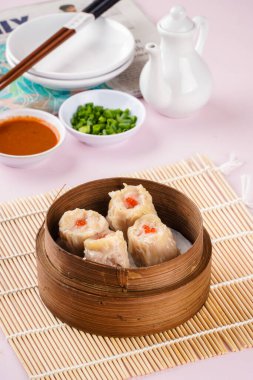 Bambu sepetinde çeşit çeşit Çin Dimsum 'u. Dimsum, Kanton halkının geleneksel olarak kahvaltı ve öğle yemeği için restoranlarda yediği küçük tabakların geniş bir yelpazesidir..