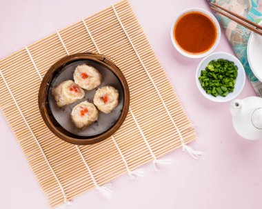 Bambu sepetinde çeşit çeşit Çin Dimsum 'u. Dimsum, Kanton halkının geleneksel olarak kahvaltı ve öğle yemeği için restoranlarda yediği küçük tabakların geniş bir yelpazesidir..