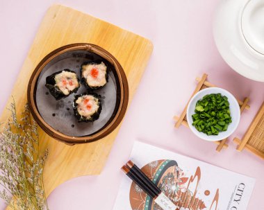 Bambu sepetinde çeşit çeşit Çin Dimsum 'u. Dimsum, Kanton halkının geleneksel olarak kahvaltı ve öğle yemeği için restoranlarda yediği küçük tabakların geniş bir yelpazesidir..