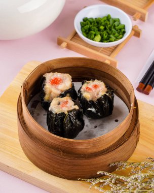 Bambu sepetinde çeşit çeşit Çin Dimsum 'u. Dimsum, Kanton halkının geleneksel olarak kahvaltı ve öğle yemeği için restoranlarda yediği küçük tabakların geniş bir yelpazesidir..