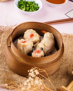Bambu sepetinde çeşit çeşit Çin Dimsum 'u. Dimsum, Kanton halkının geleneksel olarak kahvaltı ve öğle yemeği için restoranlarda yediği küçük tabakların geniş bir yelpazesidir..