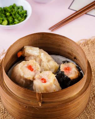 Bambu sepetinde çeşit çeşit Çin Dimsum 'u. Dimsum, Kanton halkının geleneksel olarak kahvaltı ve öğle yemeği için restoranlarda yediği küçük tabakların geniş bir yelpazesidir..