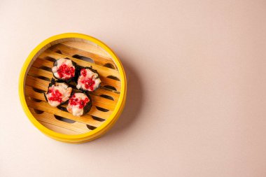 Bambu buharlı sepetinde yengeç yosunlu börek. Dimsum, Kanton halkının geleneksel olarak kahvaltı ve öğle yemeği için restoranlarda yediği küçük tabakların geniş bir yelpazesidir..