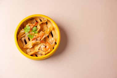Bambu buharlı sepetinde karides köftesi. Dimsum, Kanton halkının geleneksel olarak kahvaltı ve öğle yemeği için restoranlarda yediği küçük tabakların geniş bir yelpazesidir..