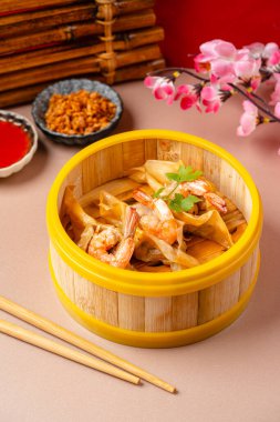 Bambu buharlı sepetinde karides köftesi. Dimsum, Kanton halkının geleneksel olarak kahvaltı ve öğle yemeği için restoranlarda yediği küçük tabakların geniş bir yelpazesidir..