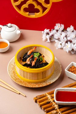 Bambu buharlı sepetinde karides yosunlu börek. Dimsum, Kanton halkının geleneksel olarak kahvaltı ve öğle yemeği için restoranlarda yediği küçük tabakların geniş bir yelpazesidir..