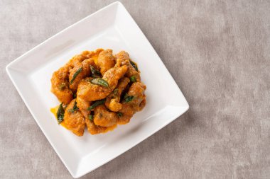 Beyaz tabakta tuzlanmış yumurtayla kaplanmış kızarmış dori balığı.