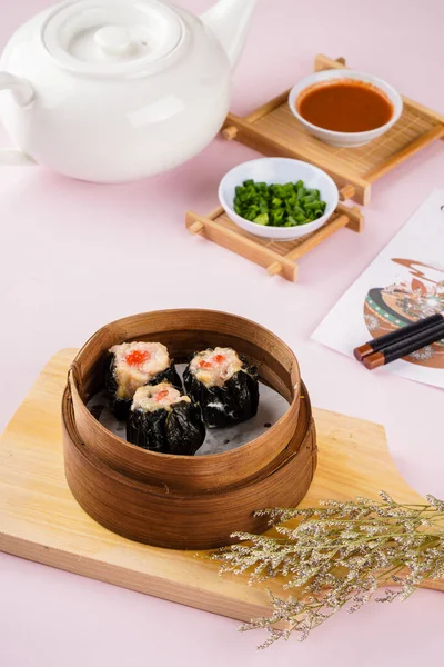 Bambu sepetinde çeşit çeşit Çin Dimsum 'u. Dimsum, Kanton halkının geleneksel olarak kahvaltı ve öğle yemeği için restoranlarda yediği küçük tabakların geniş bir yelpazesidir..