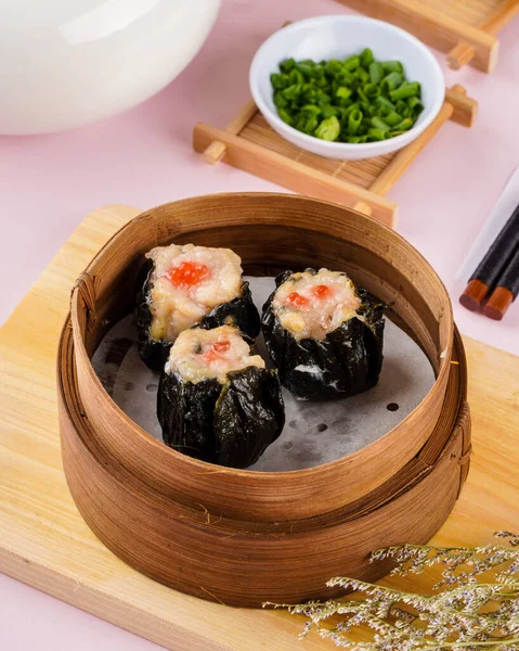 Bambu sepetinde çeşit çeşit Çin Dimsum 'u. Dimsum, Kanton halkının geleneksel olarak kahvaltı ve öğle yemeği için restoranlarda yediği küçük tabakların geniş bir yelpazesidir..