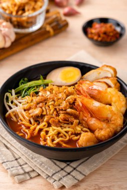 Hokkien mee veya karidesli erişte domuz yağına karıştırılır ve balık köftesi ve karides ile servis edilir..