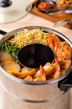 Hokkien mee veya karidesli erişte domuz yağına karıştırılır ve balık köftesi ve karides ile servis edilir..
