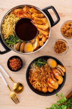 Hokkien mee veya karidesli erişte domuz yağına karıştırılır ve balık köftesi ve karides ile servis edilir..