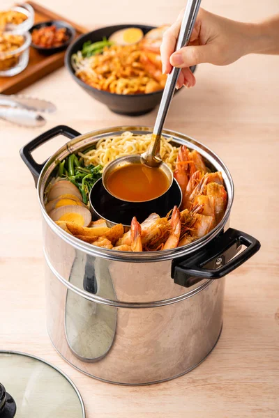 Hokkien mee veya karidesli erişte domuz yağına karıştırılır ve balık köftesi ve karides ile servis edilir..