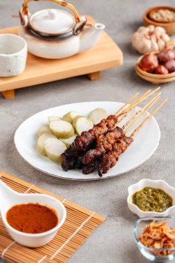 Pork Satay ya da Sate Babi. Pork Satay, fıstık sosu ve bir dilim lontong veya ketupat ile servis edilir.)