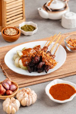 Pork Satay ya da Sate Babi. Pork Satay, fıstık sosu ve bir dilim lontong veya ketupat ile servis edilir.)