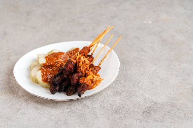 Pork Satay ya da Sate Babi. Pork Satay, fıstık sosu ve bir dilim lontong veya ketupat ile servis edilir.)
