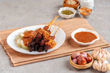 Pork Satay ya da Sate Babi. Pork Satay, fıstık sosu ve bir dilim lontong veya ketupat ile servis edilir.)