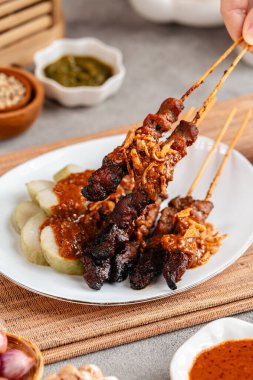 Pork Satay ya da Sate Babi. Pork Satay, fıstık sosu ve bir dilim lontong veya ketupat ile servis edilir.)