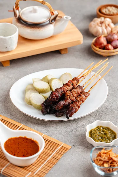 Pork Satay ya da Sate Babi. Pork Satay, fıstık sosu ve bir dilim lontong veya ketupat ile servis edilir.)