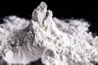 Kaolin on isolated black background, is an inorganic mineral, chemically inert, used in several branches of industry, from cosmetics to dye clipart