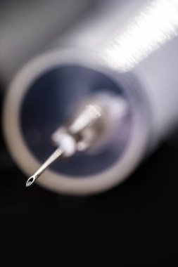 İzole edilmiş siyah zemin üzerinde şırınga ya da enjeksiyon, iğnenin ucunda nokta odaklı