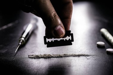 Bir parça kokain, solunacak beyaz toz, bağımlılık ve kimyasal bağımlılık kavramı, uyuşturucu satıcısı ve satışı