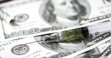 100 dolarlık banknotlar ve içinde beyaz toz, eroin, kokain ve para olan şırınga. Uyuşturucu satıcıları kavramı, uluslararası uyuşturucu satışı