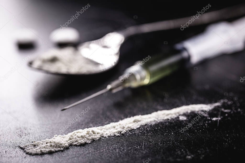 cocaine and heroin on dark wooden table, concept of addiction and chemical dependency, illegal drugs