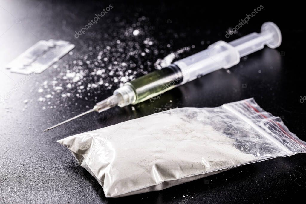 bag of cocaine and heroin syringe, drugs being sold and packaged. Concept of trafficking and sale of illegal substances