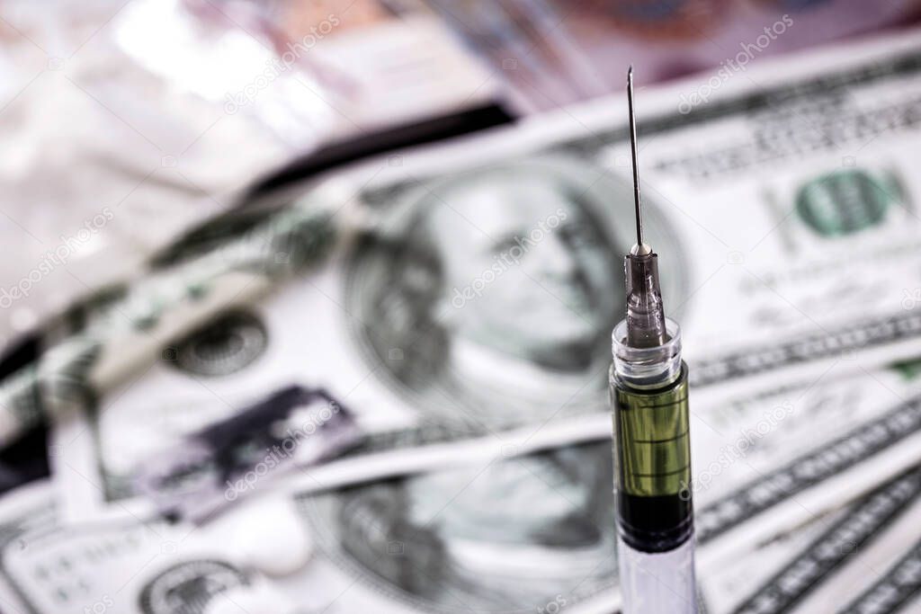 dollar bills and syringe with white powder, heroin and cocina and money. Drug traffickers concept, international drug sales