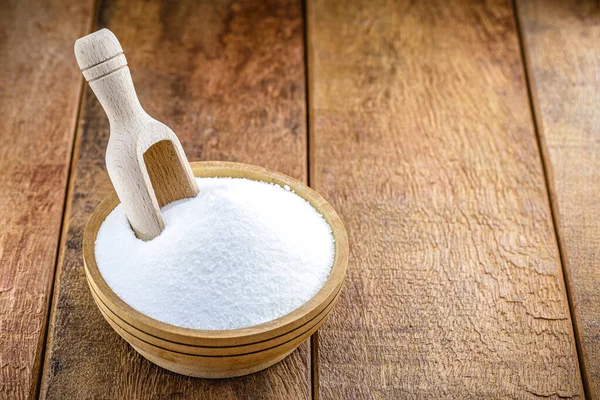 baking soda (baking soda) in a wooden spoon, rustic background