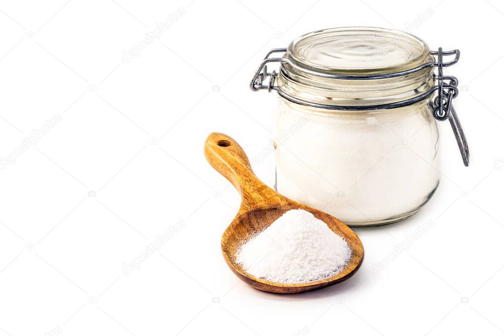 Glass jar and wooden spoon with baking soda on isolated white background, chemical compound in crystalline powders, used as antacid or as yeast