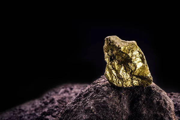 gold nugget on stone, gold inside cave, concept of rarity and luxury