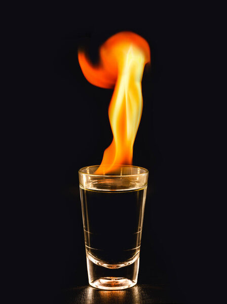 Горящие алкогольные напитки с большим пламенем, на черном фоне с копировальным пространством