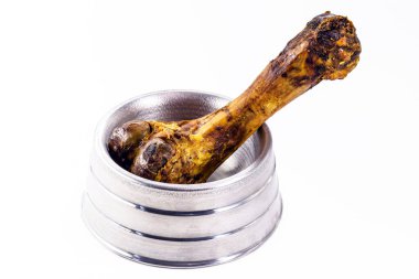 Evcil hayvan kasesinin içindeki yapay kemik, beyaz arka plandaki köpek için yenebilir gerçekçi oyuncak..